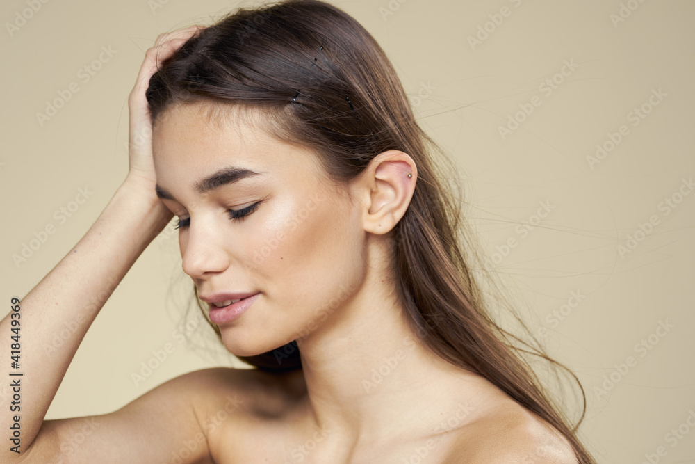 Pretty woman naked shoulders long hair body care beige background Pretty woman naked shoulders long hair body care beige background