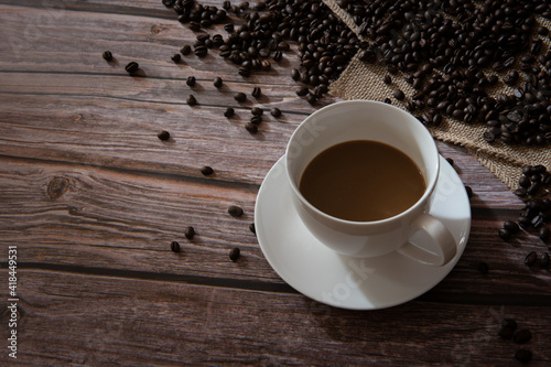 Coffee in white cup And coffee beans on the wooden table