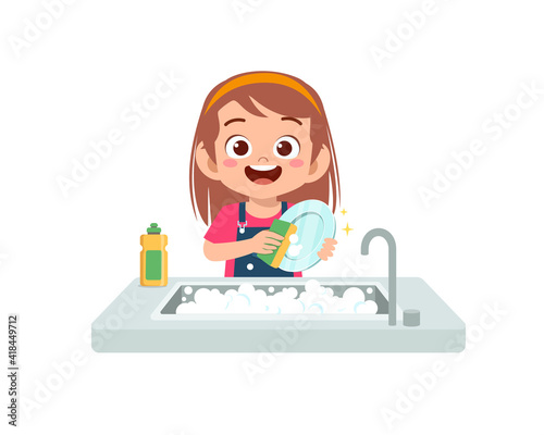 happy cute little girl washing dish in the kitchen