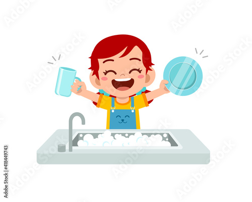 happy cute little girl washing dish in the kitchen