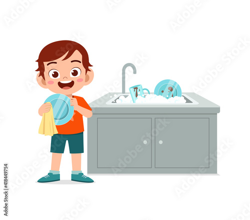 happy cute little boy washing dish in the kitchen