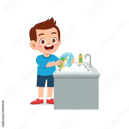 happy cute little boy washing dish in the kitchen