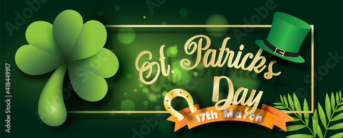 Giant shamrock plants with golden Horseshoe and Saint Patrick's Day letters, high hat and the day of event's ribbon on blurred and bokeh green background.