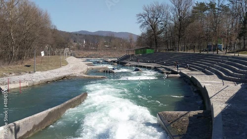 Professional athletes training canoe slalom on white water rapids. Canoe slalom competition course on fast flowing river photo