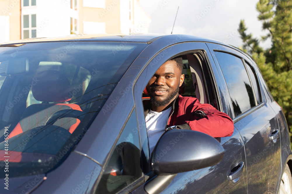 Happy African American in a blue car