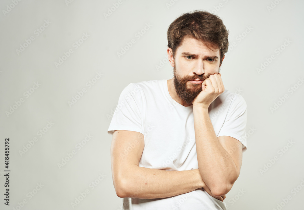 Man touches face with hands emotions model light background Man touches face with hands emotions model light background