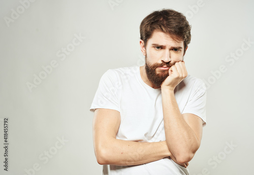 Man touches face with hands emotions model light background