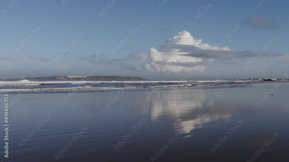 Beach with clouds and reflections, with the city skyline of Essaouira, a fishing coastal town. Touristic travel destination of Morocco. Beach with clouds and reflections, with the city skyline of Essaouira, a fishing coastal town. Touristic travel destination of Morocco.