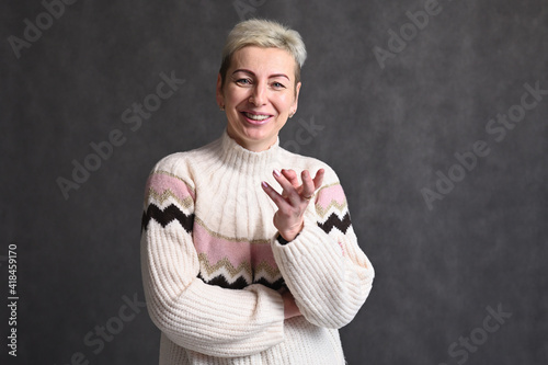 Portrait of adult blond caucasian woman on gray background