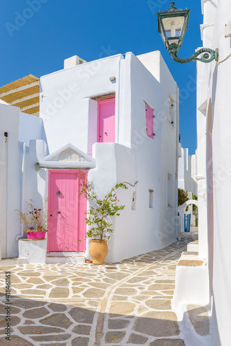 Fototapeta Naklejka Na Ścianę i Meble -  Traditional Cycladitic alley with narrow street, whitewashed houses and a blooming bougainvillea in Marpissa Paros island, Greece.