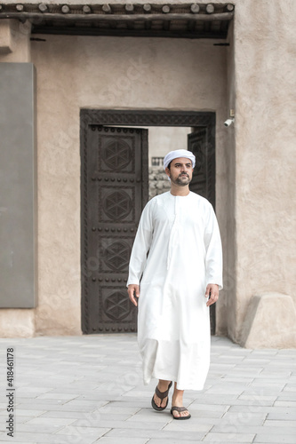arab man in traditional clothing coming out of a door