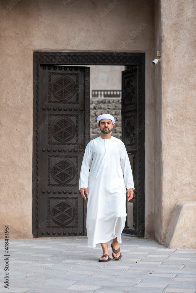 arab man in traditional clothing coming out of a door