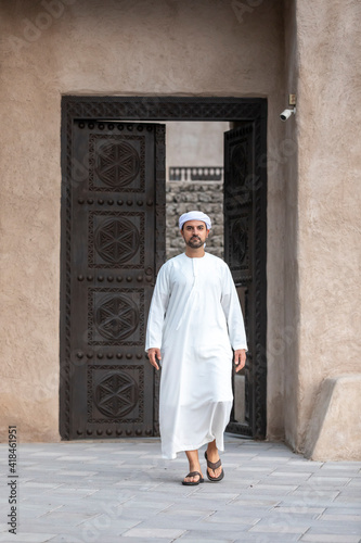 arab man in traditional clothing coming out of a door