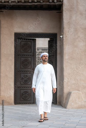 arab man in traditional clothing coming out of a door
