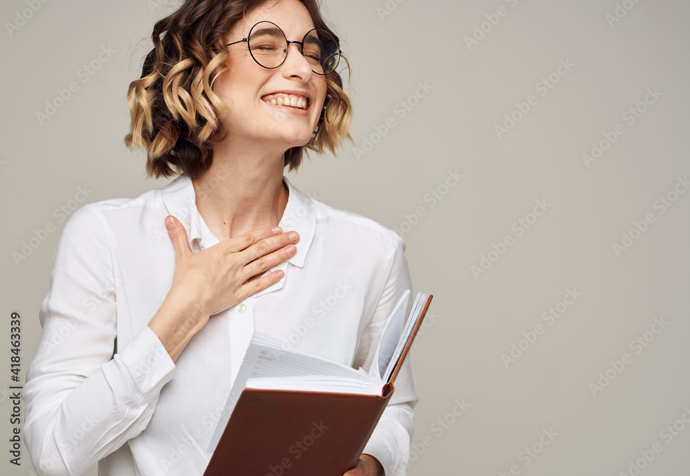 woman with notepad on gray background indoors gesturing with hands work office education woman with notepad on gray background indoors gesturing with hands work office education