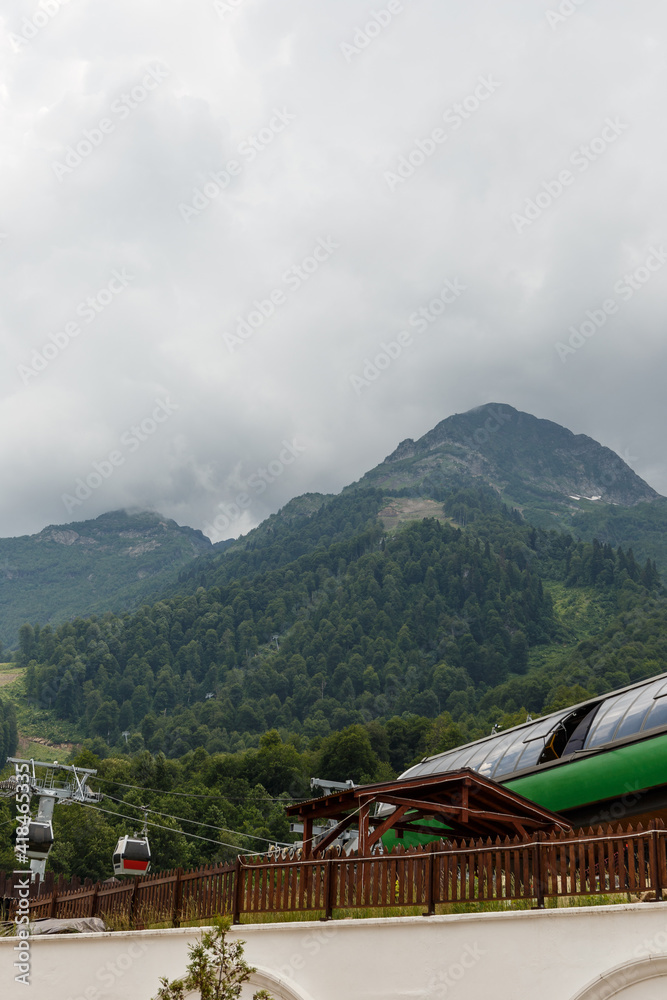 Misty mountain landscape with fir forest. Beautiful landscape with mountain view, cable car. Postcard view. Travel concept