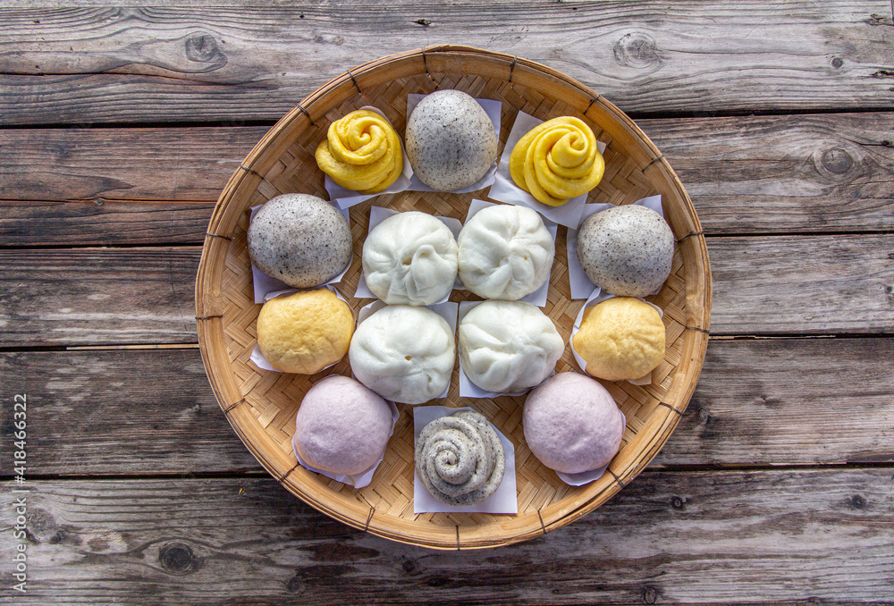 Steamed bun,yellow Steamed bun ,purple Steamed bun on bamboo basket in morning top view wooden background