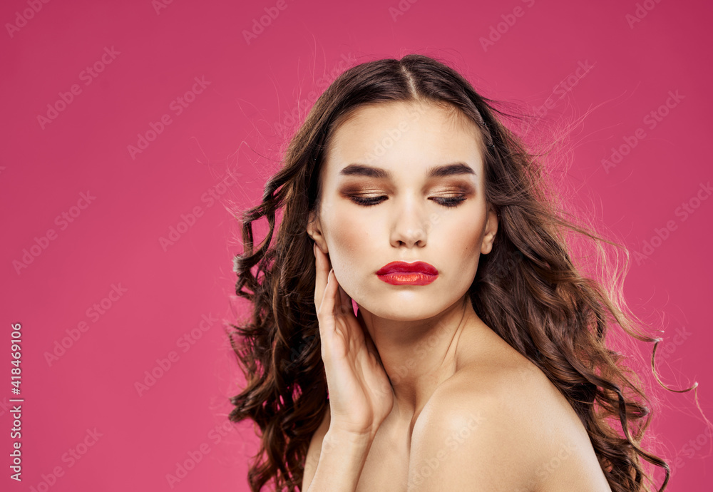 Romantic woman with red lips posing on a pink background Romantic woman with red lips posing on a pink background
