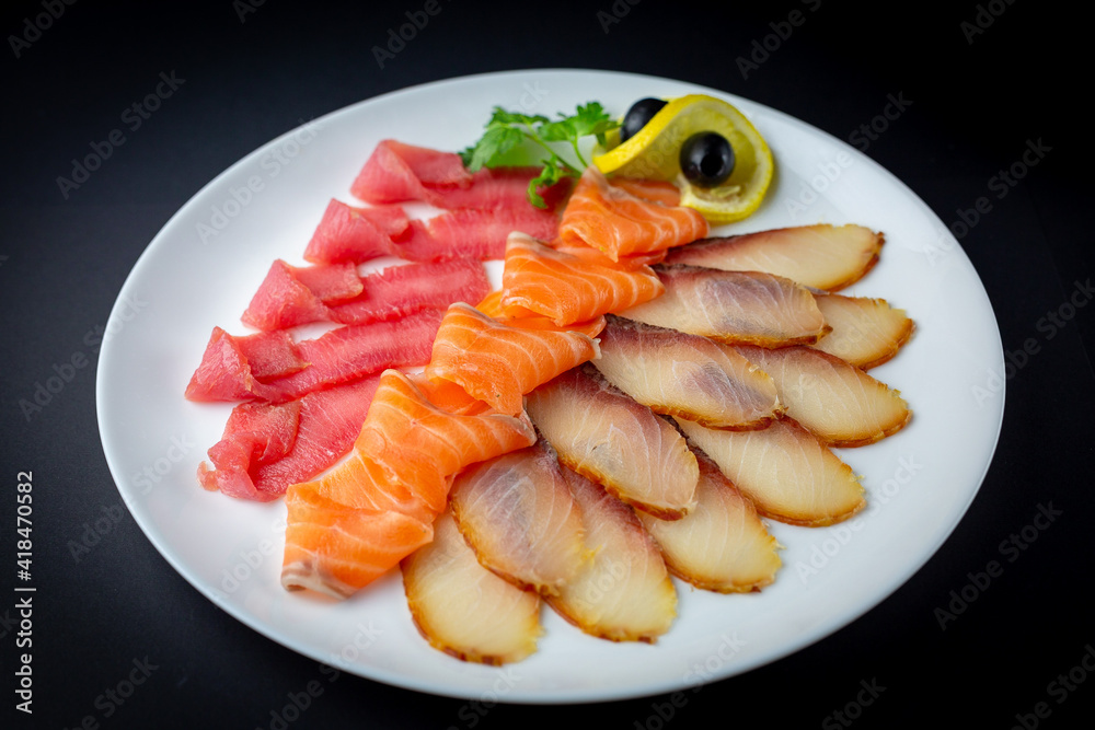 Fish platter on the white plate and black background isolated.