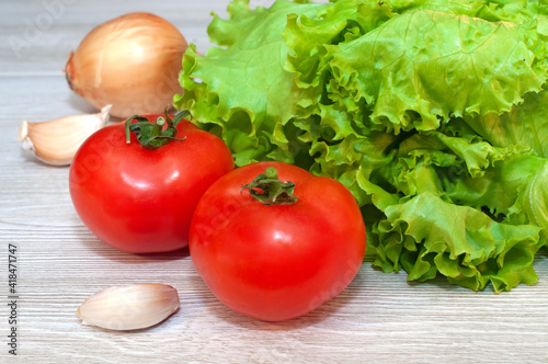 Red tomatoes and lettuce on the table. Vegetarian healthy food