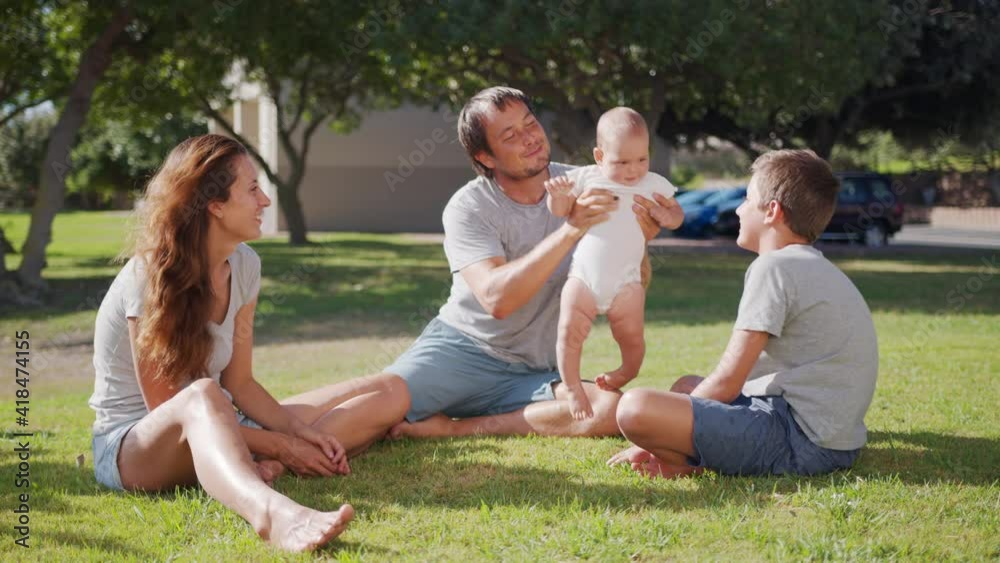 Family walk with baby toddler making first steps on park grass happy family play together on nature. Family walk with baby toddler making first steps on park grass happy family play together on nature.