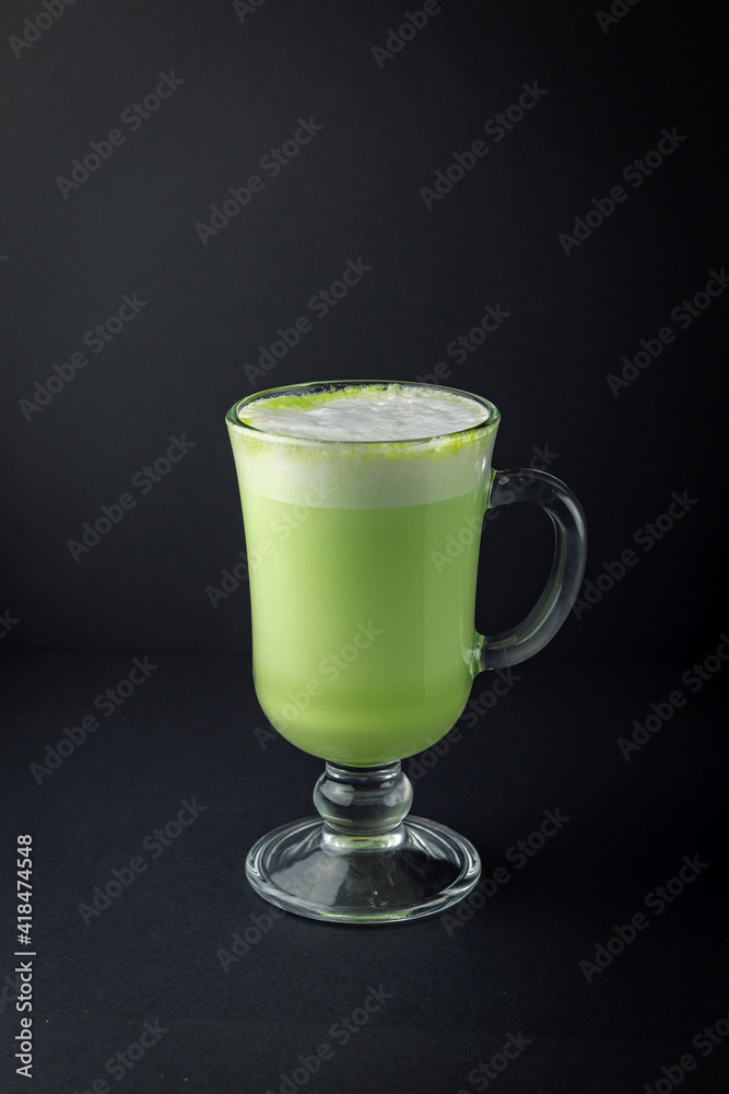 Matcha latte in a glass cup on black background. Matcha latte in a glass cup on black background.