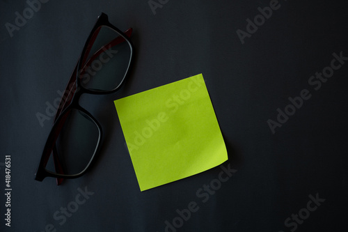 Note paper and glasses on a gray-black background, Reminder paper