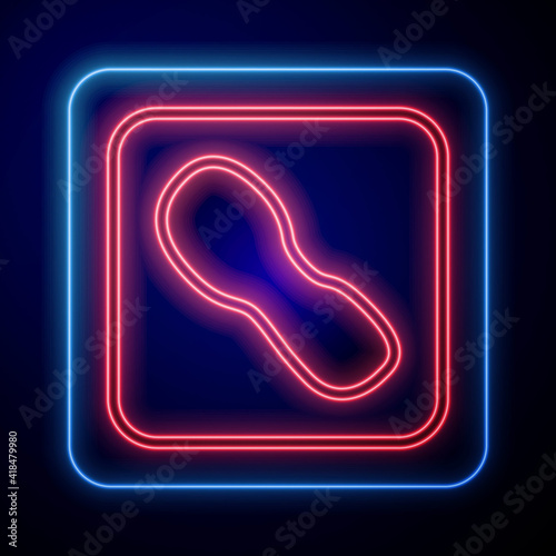 Glowing neon Human footprints shoes icon isolated on black background. Shoes sole. Vector.