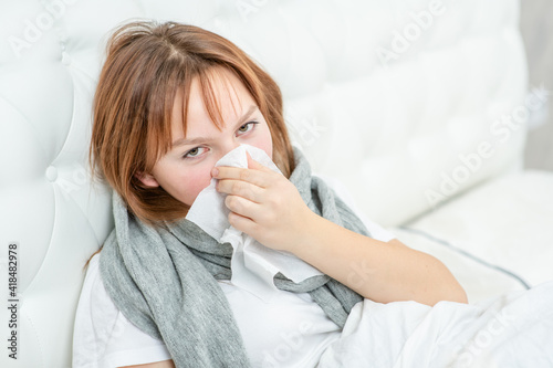 Sick girl blowing her nose in a handkerchief