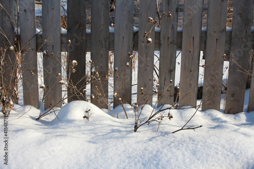 old wooden fence made of planks in the snow for decorative fencing