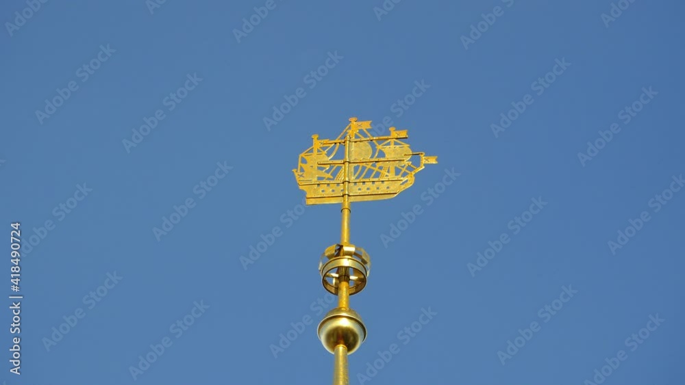sailing ship weather vane on the spire of the Admiralty high in the blue sky, symbol of St. Petersburg is rotated from the wind, low angle sailing ship weather vane on the spire of the Admiralty high in the blue sky, symbol of St. Petersburg is rotated from the wind, low angle