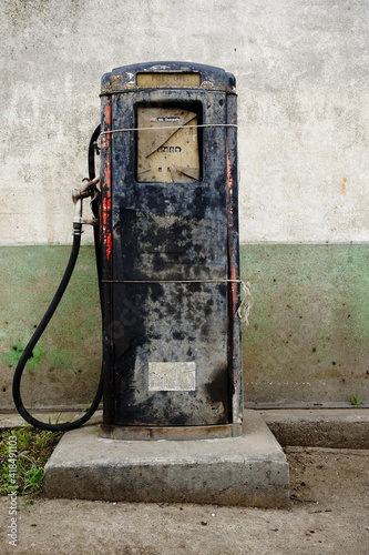 Vintage gas pump in front of a disused old gas station