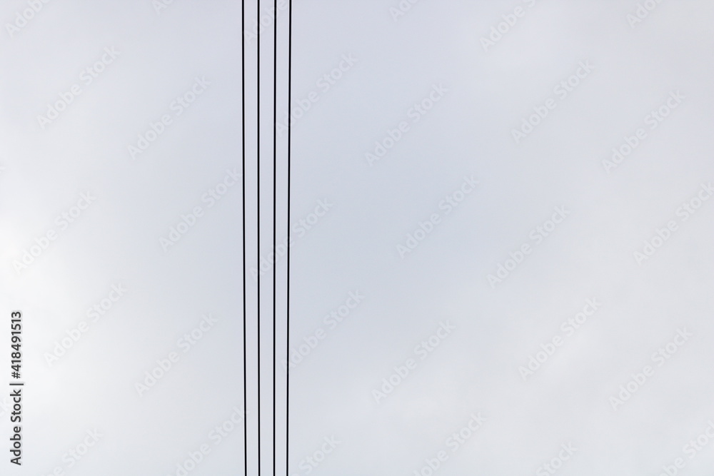 Power lines against cloudy sky, abstract