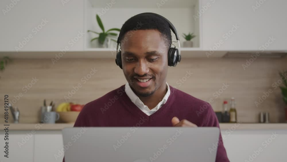 African american young black male enterpreneur working on his laptop in his bright home office happy and calm African american young black male enterpreneur working on his laptop in his bright home office happy and calm