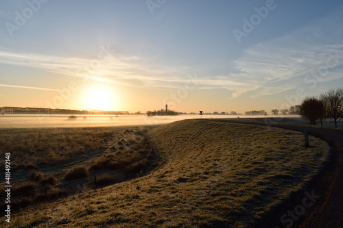 A scenic view of a winding Dutch road overlooking a meadow filled with ground frost close to Oss, netherlands © Mark Buckingham