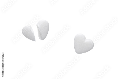 White pills in the shape of a heart isolated on white background. pills sliced in half.