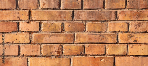 Orange brown damaged rustic grunge brick wall / masonry / brickwork texture background banner wallpaper template