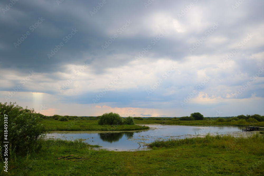 View of a small lake before the rain. View of a small lake before the rain.