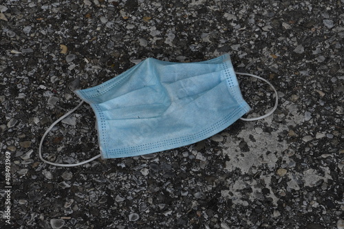 discarded face mask lies on the ground