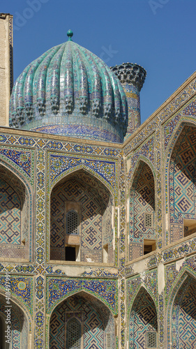Corner view with dome and arches in courtyard of Ulugh Beg madrassa on Registan square in UNESCO listed Samarkand, Uzbekistan