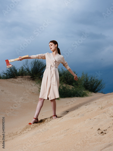 A woman with an ax in a sundress and red shoes stands at the board