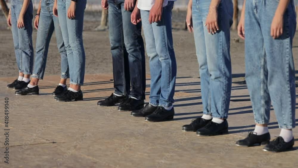 People in blue jeans and black shoes stand in one line. People are waiting for the command to take action. People in blue jeans and black shoes stand in one line. People are waiting for the command to take action.