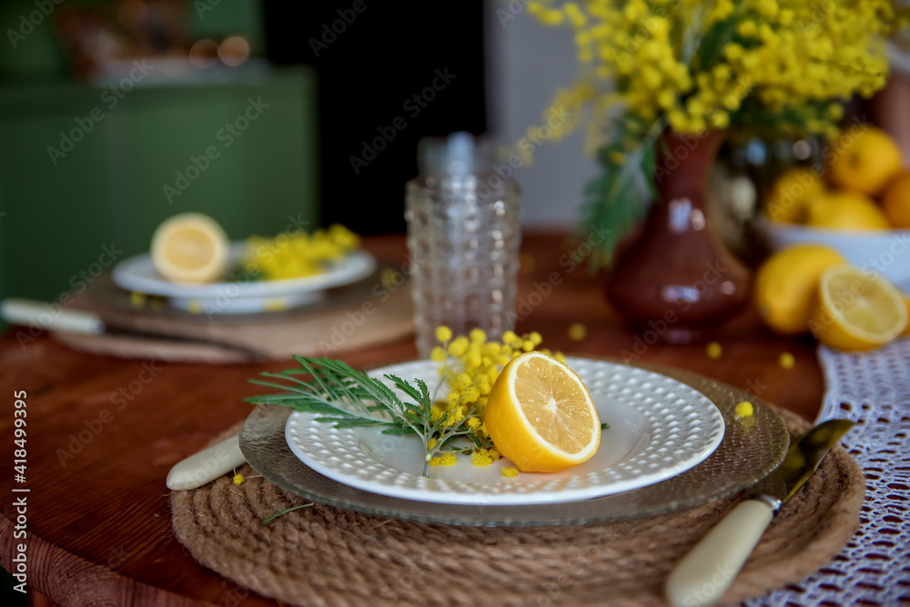Set table with decoration of yellow flowers and lemons