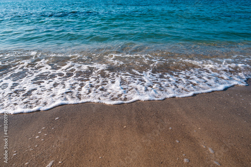 Seascape. Waves running on the sandy shore. Shore of the sea or ocean on a nice day. Vacation and relaxation by the sea.