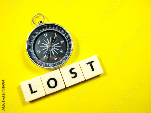 Selective focus.Compass with word LOST on yellow background.Travel and holiday concept.