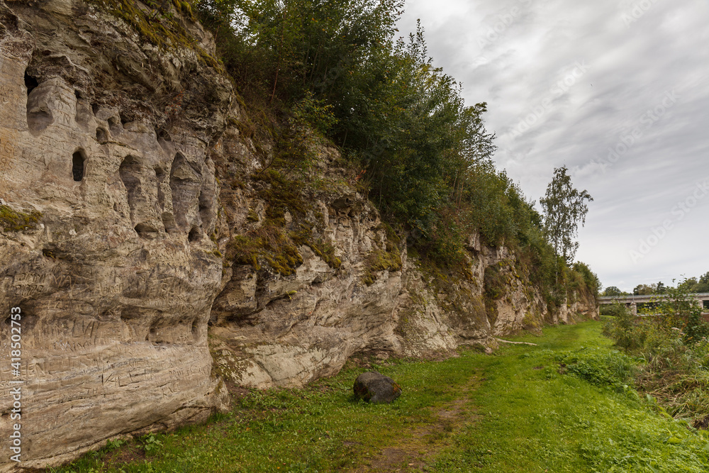 Exposed rocky cliff with caves in Tori, Estonia. Local name - Devil's caves Exposed rocky cliff with caves in Tori, Estonia. Local name - Devil's caves