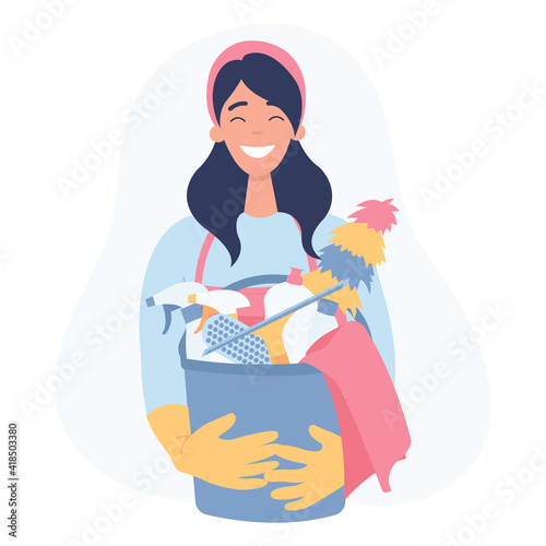 Young woman holding cleaning tools and products in bucket. Cleaning service concept.