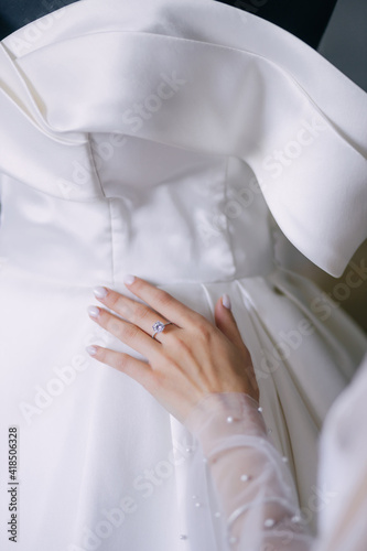close-up of a bride's hand with a beautiful manicure on a wedding dress.