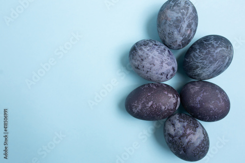 Easter eggs is a marble-blue colour on a blue background with copy space. Happy Easter 2021.