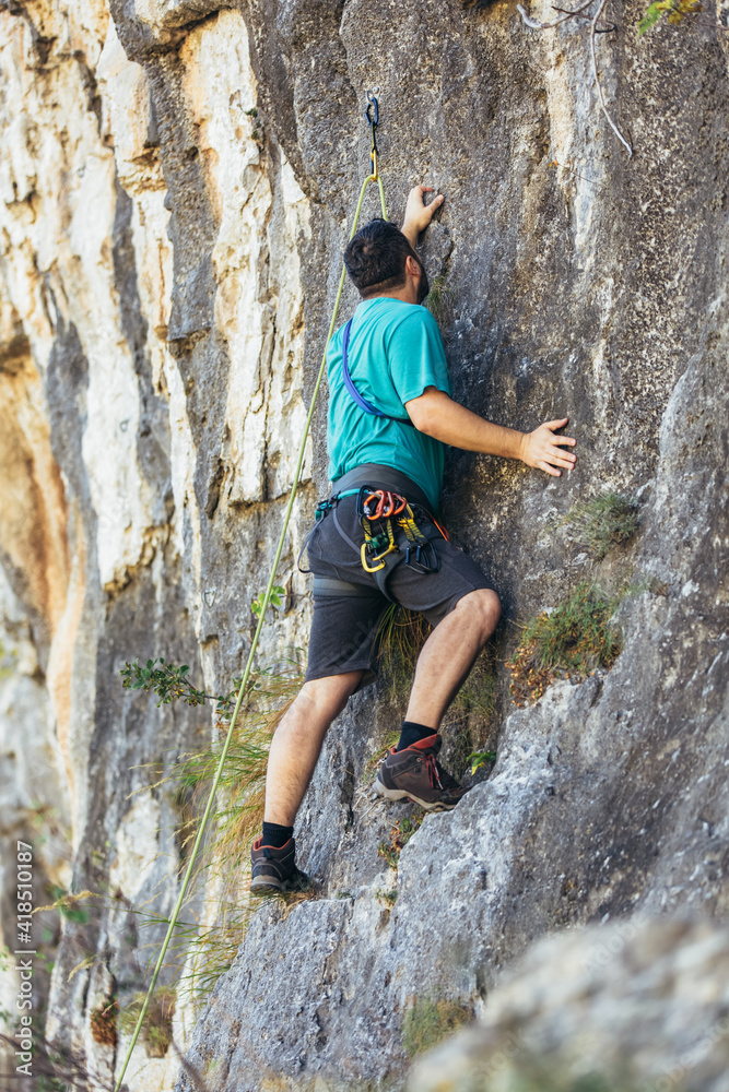 Climber climbs on the rock wall. Climbing gear. Climbing equipment.